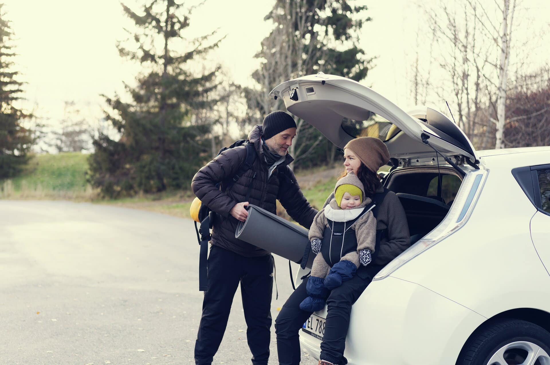 Famile laster inn bagasje i en Nissan Leaf.