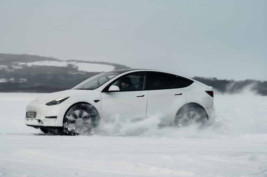 Tesla Model Y kjører i snøføyk.