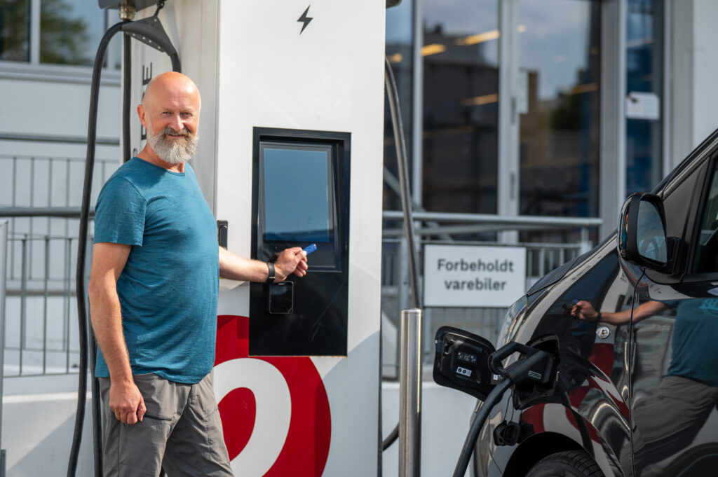 Man som bruker ladebrikke for å hurtiglade elbil.