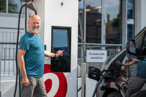 Man som bruker ladebrikke for å hurtiglade elbil.